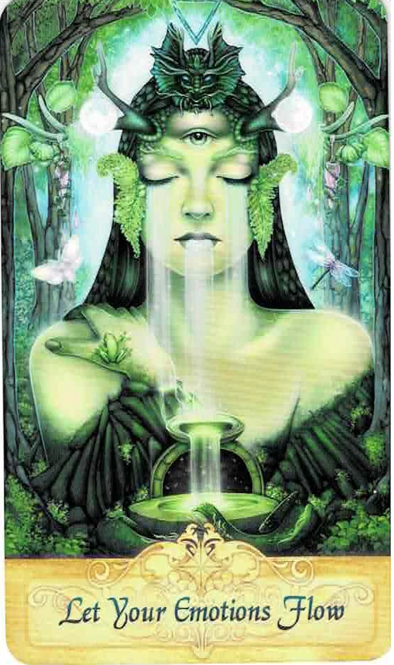 Messenger Oracle card with a backdrop of a faerie wood entrance of arched tree bows. At the front is an image of Gaia in a green gown with shoulders exposed, her right hand holding her shoulder on the same side and a frog is perched just at her thumb. At her crown is a headdress of a jade dragon and antlers coming out from each side of her forehead supporting orbs of pure white. Water flows from her closed eyes and mouth into a double tiered bowl, the bottom bowl has an archway leading to a starry night sky in the background. To her right is a bright white and pink moth and at her left is a dragonfly with translucent pink wings. At the bottom is a golden plaque with ornate scrollwork and the words Let Your Emotions Flow