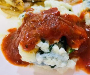 Close up of gnudi topped with marinara